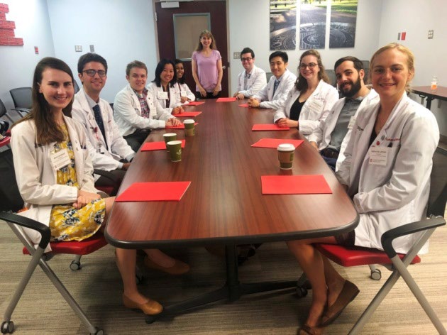 medical students attending a lecture given by a pathology faculty member.