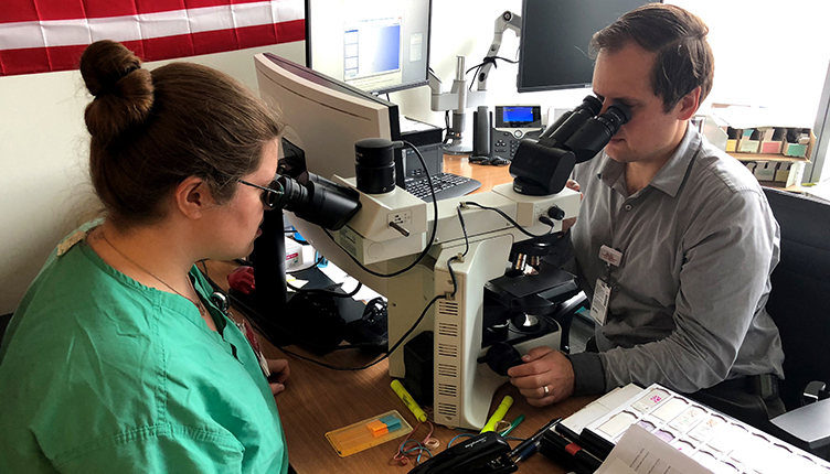 A Female medical student and Dr. Peter Kobalka review slides during the one-on-one sign-out portion of the Surgical Pathology Rotation.