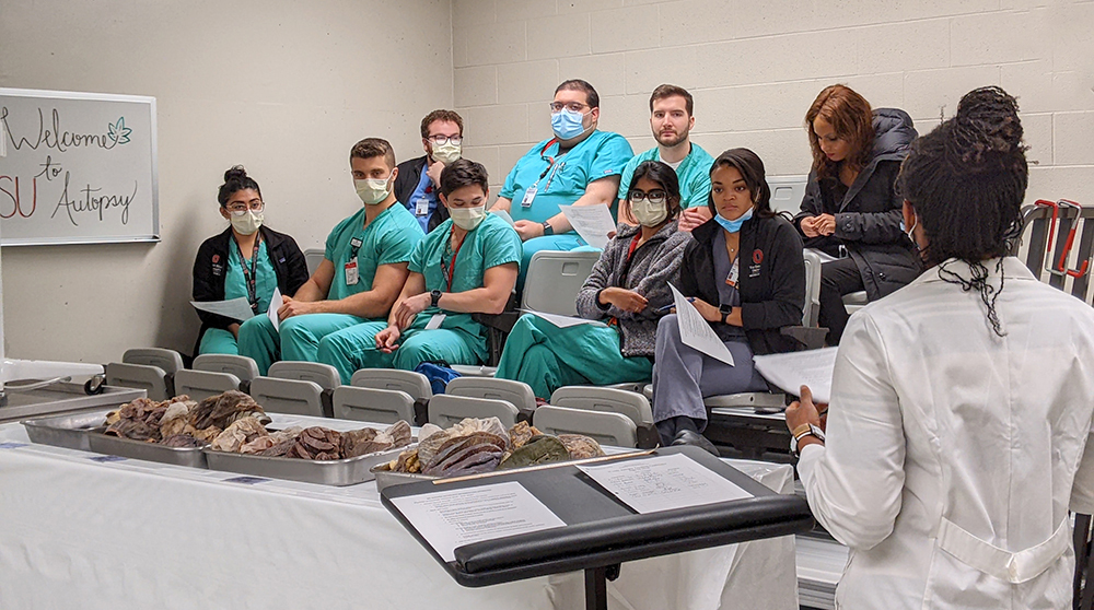 medical students attending a lecture given by a pathology faculty member.