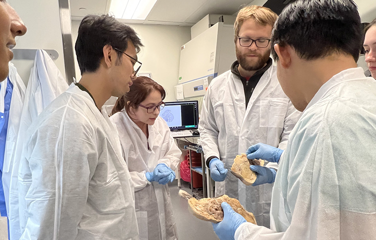 Pathology students observe a human foot in the gross room